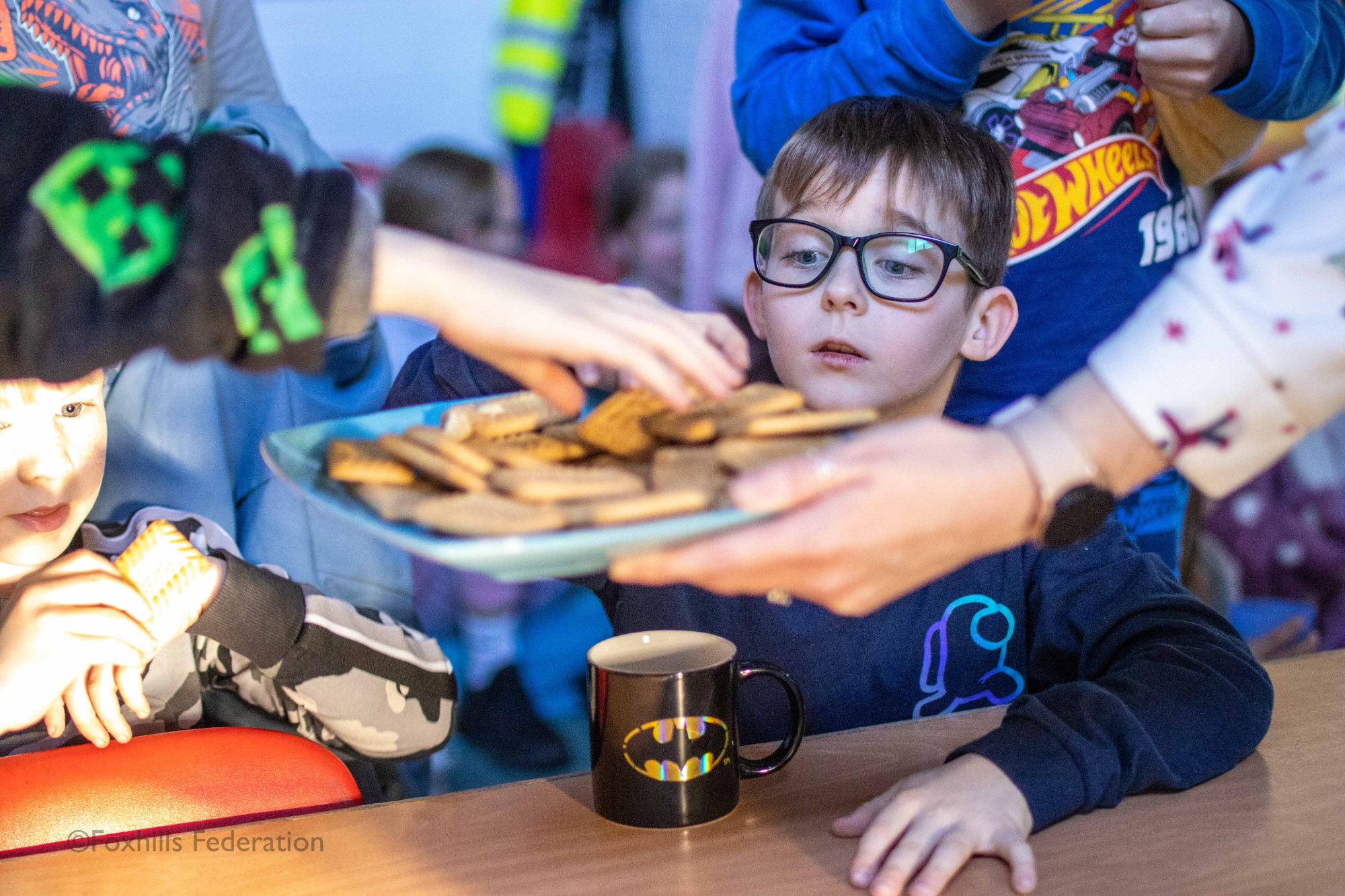 A boy looks at a tray of buscuits